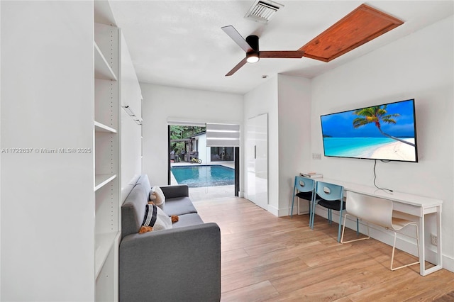 living room featuring ceiling fan and light wood-type flooring