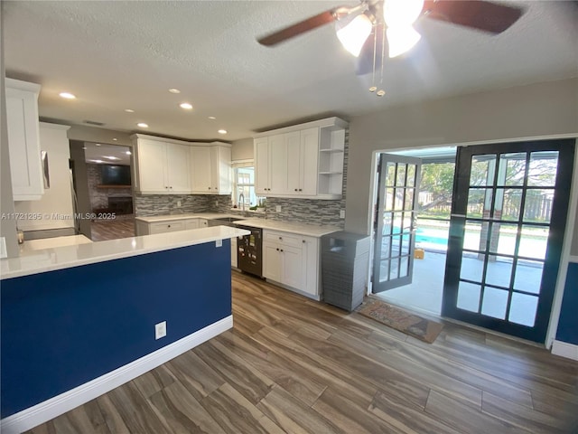 kitchen with decorative backsplash, ceiling fan, white cabinetry, and beverage cooler