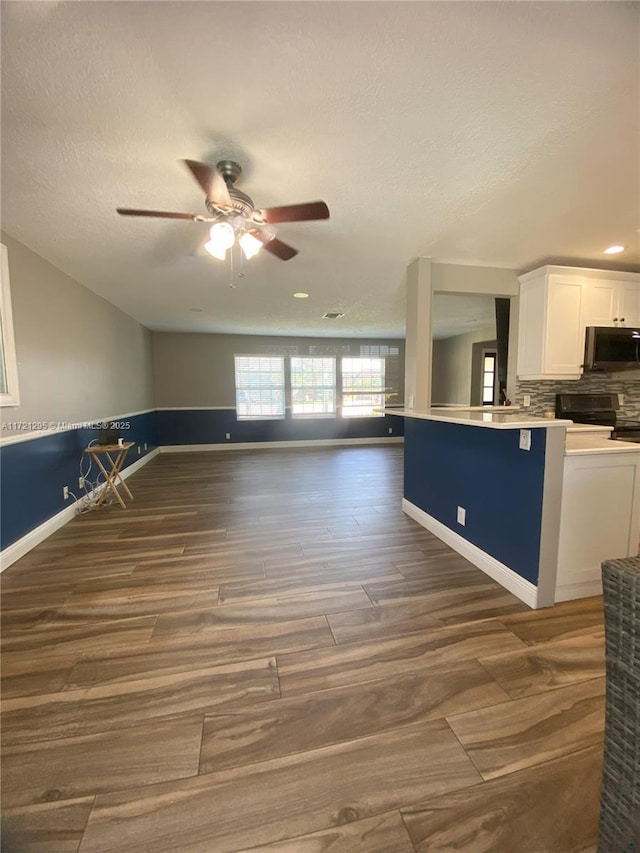 kitchen featuring white cabinetry, ceiling fan, electric range, dark hardwood / wood-style flooring, and backsplash