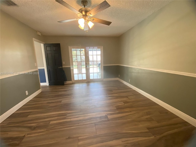 unfurnished room featuring ceiling fan, dark hardwood / wood-style floors, a textured ceiling, and french doors