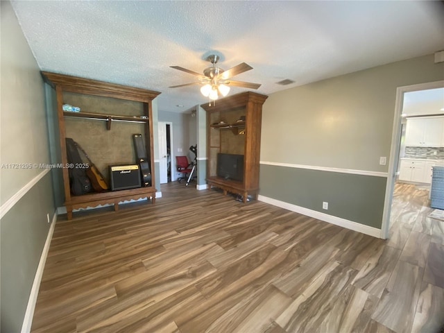 unfurnished living room with hardwood / wood-style floors, ceiling fan, and a textured ceiling