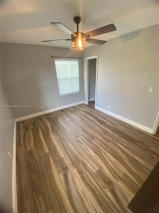 empty room featuring wood-type flooring and ceiling fan