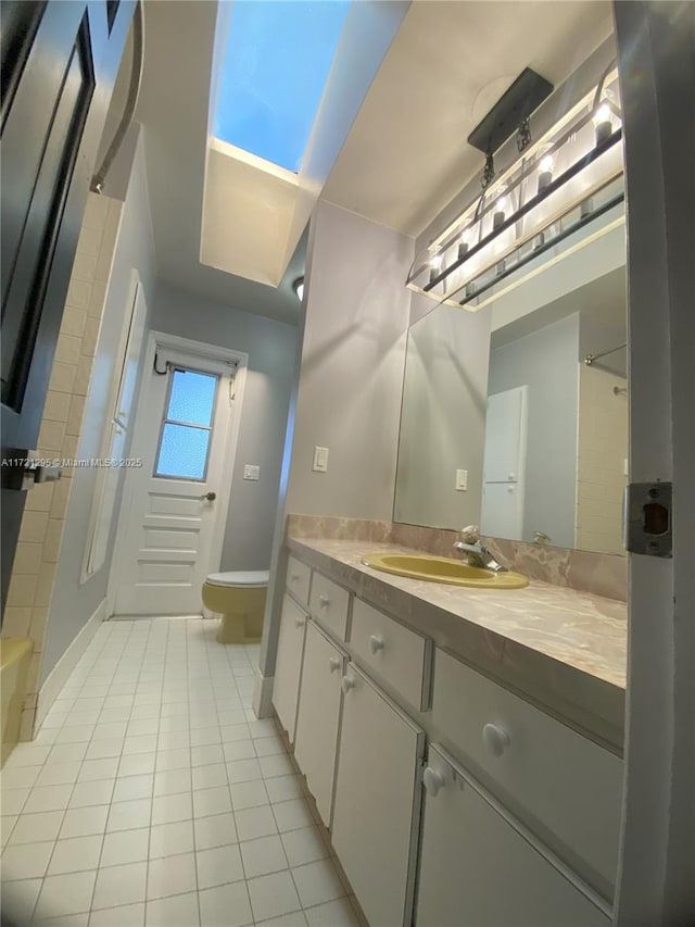 bathroom featuring tile patterned flooring, vanity, and toilet