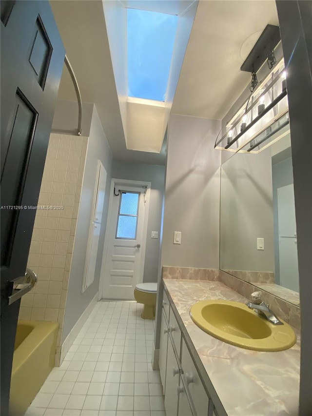 full bathroom featuring tile patterned floors, tiled shower / bath, vanity, and toilet