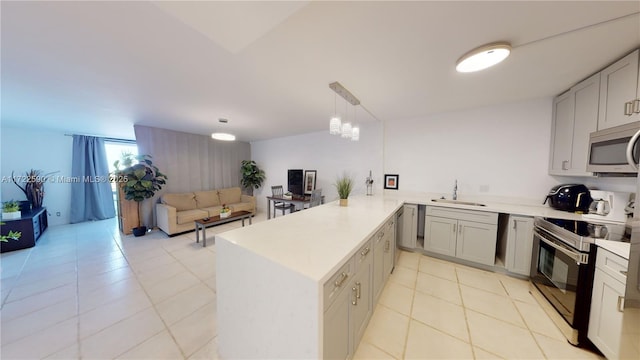 kitchen with pendant lighting, sink, light tile patterned flooring, kitchen peninsula, and stainless steel appliances