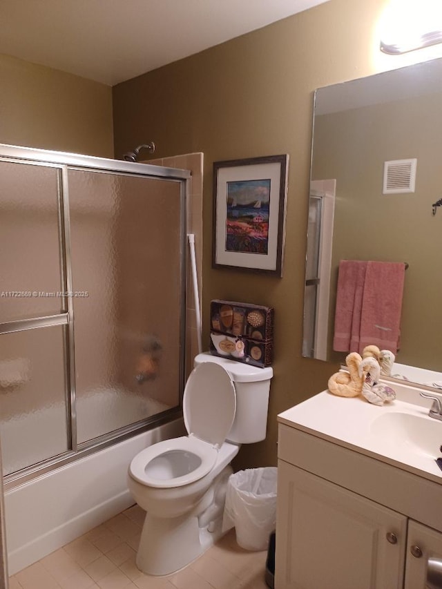 full bathroom featuring tile patterned flooring, vanity, toilet, and shower / bath combination with glass door