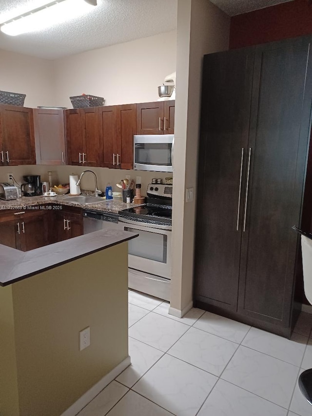 kitchen with sink, white electric range, a textured ceiling, and light tile patterned flooring