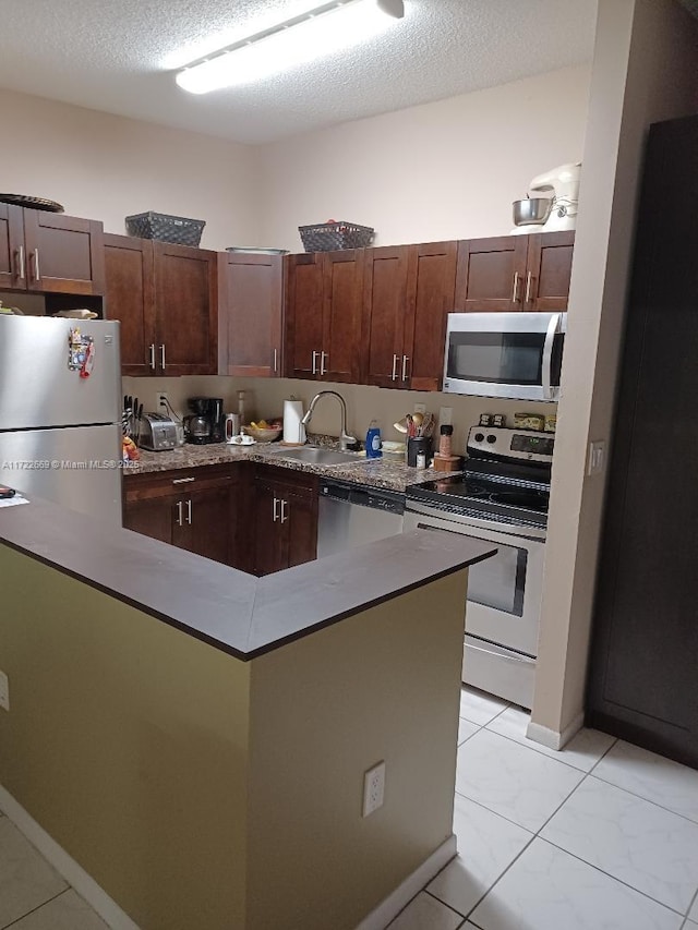 kitchen featuring light tile patterned flooring, appliances with stainless steel finishes, a textured ceiling, and sink