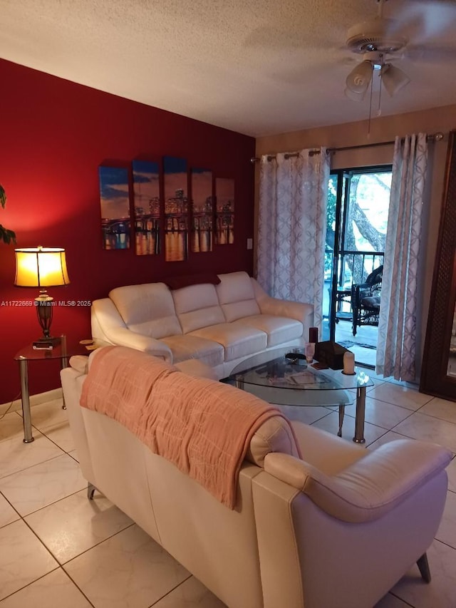 living room with a textured ceiling, ceiling fan, and light tile patterned flooring