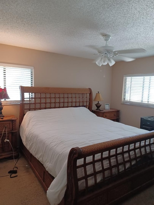 bedroom featuring ceiling fan, carpet floors, and a textured ceiling