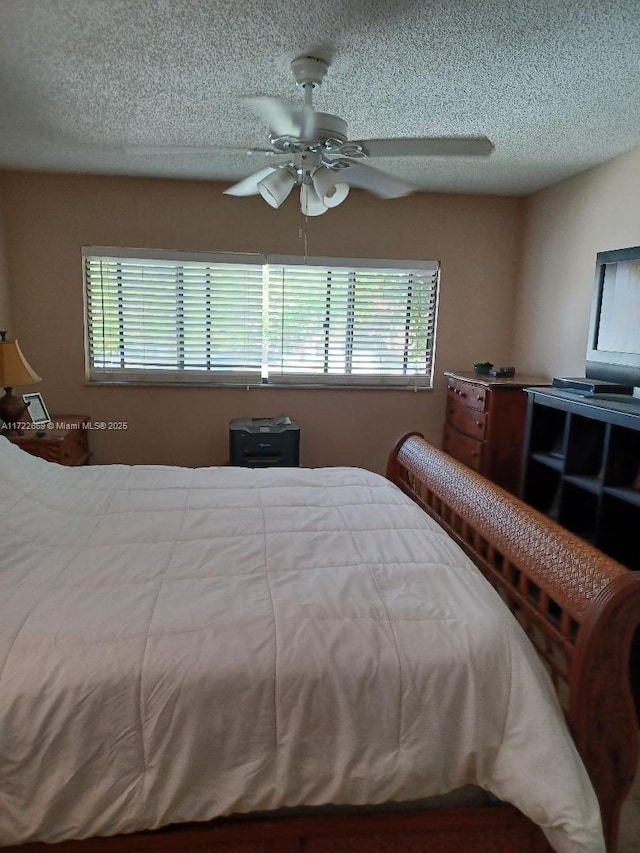 bedroom featuring ceiling fan and a textured ceiling