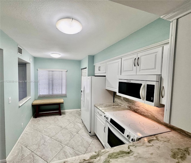 kitchen featuring white cabinetry, white appliances, light stone countertops, and a textured ceiling