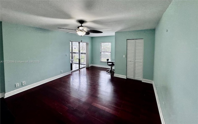 spare room with ceiling fan, dark hardwood / wood-style floors, and a textured ceiling