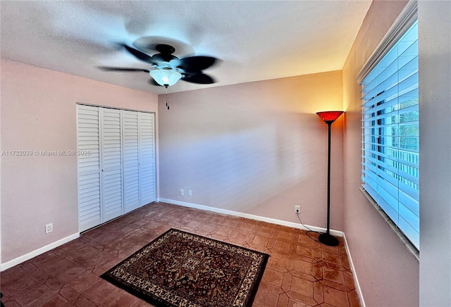 unfurnished bedroom with ceiling fan, a closet, and a textured ceiling