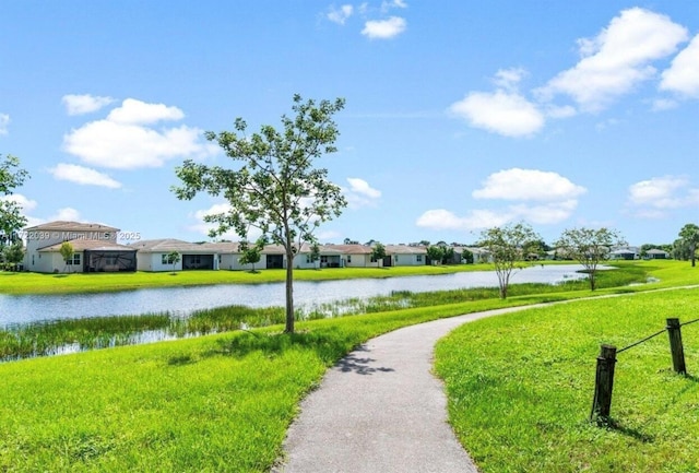 surrounding community with a water view and a yard