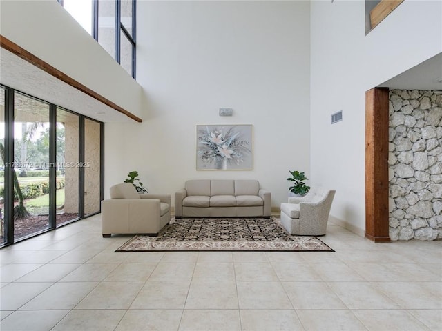 tiled living room featuring a towering ceiling