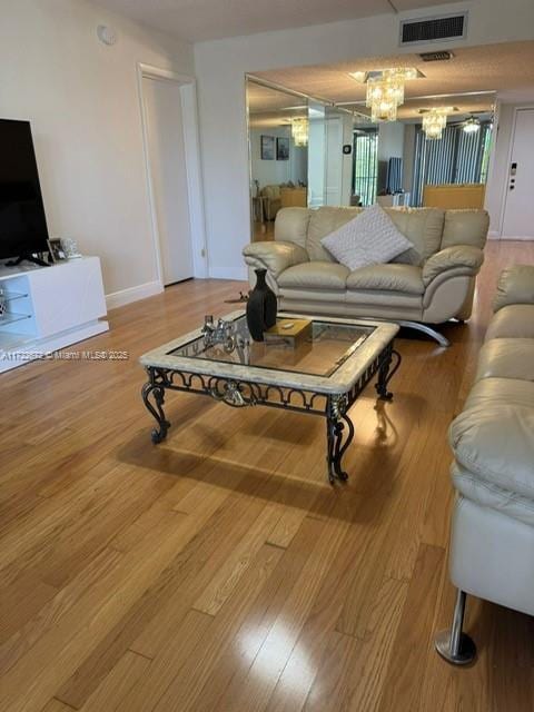 living room with a chandelier and light hardwood / wood-style flooring