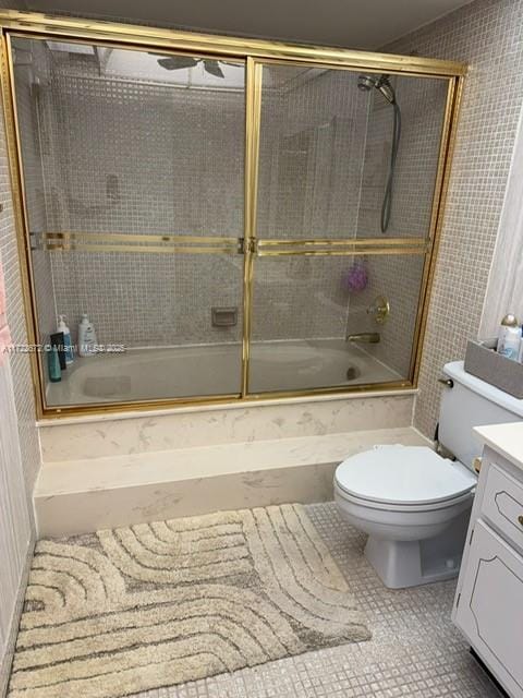 full bathroom with ceiling fan, tile patterned flooring, combined bath / shower with glass door, toilet, and vanity