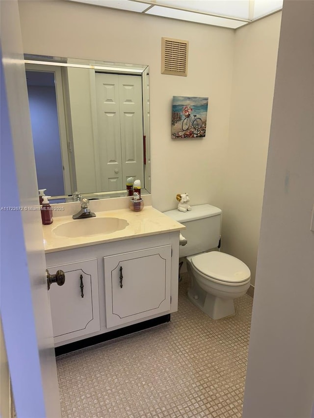 bathroom featuring tile patterned floors, vanity, and toilet