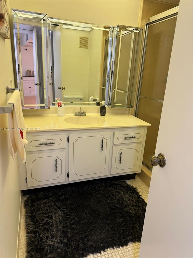 bathroom featuring vanity and a shower with shower door