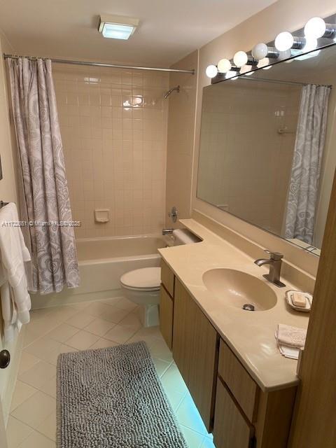 full bath with shower / bath combination with curtain, tile patterned flooring, vanity, and toilet