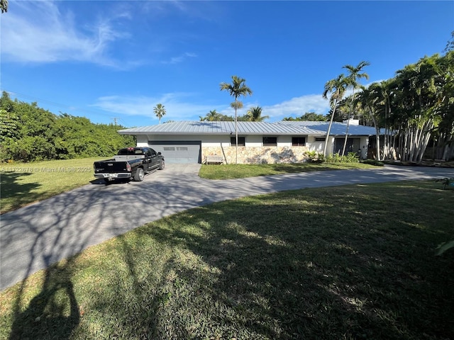 single story home featuring a garage and a front yard