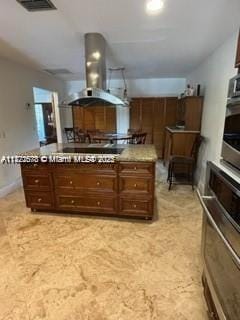 kitchen featuring wall chimney range hood and oven