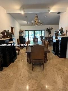 dining space with beamed ceiling and a notable chandelier