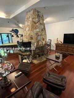 living room with a stone fireplace and ceiling fan