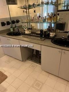 bar with sink and light tile patterned floors