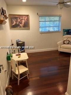 living area with wood-type flooring and ceiling fan