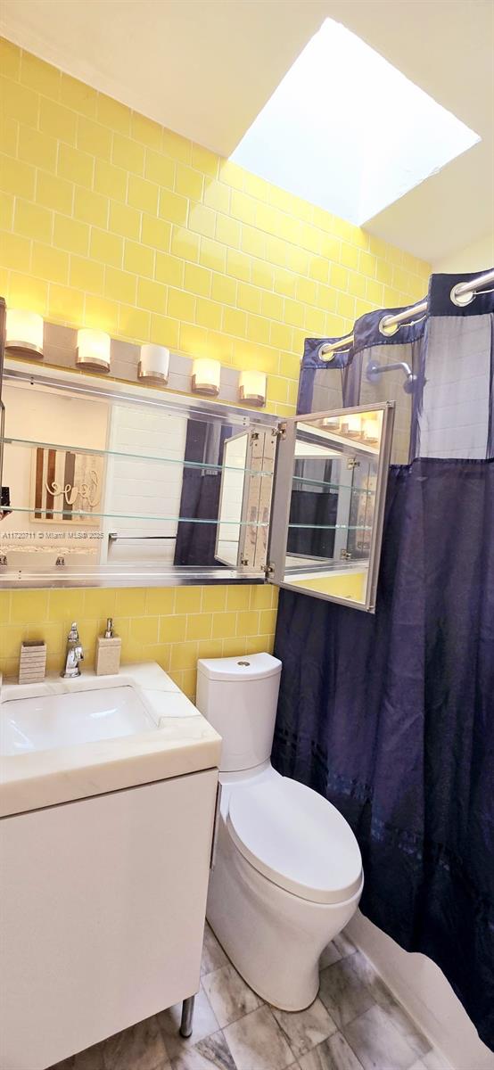 bathroom featuring backsplash, sink, and toilet