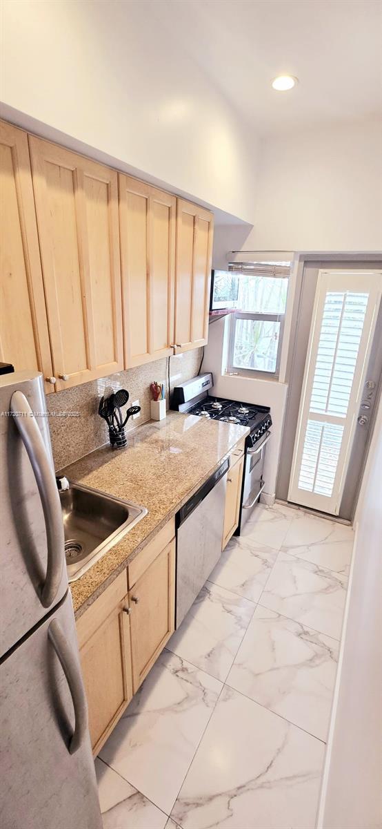 kitchen with sink, light brown cabinetry, and appliances with stainless steel finishes