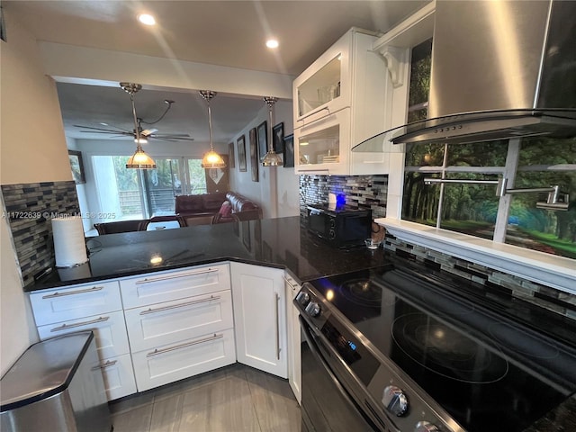 kitchen with electric range, white cabinets, backsplash, and extractor fan