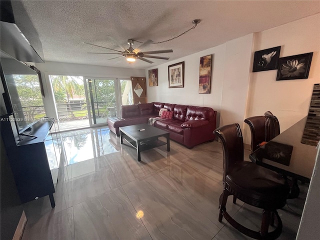 living room with a textured ceiling and ceiling fan