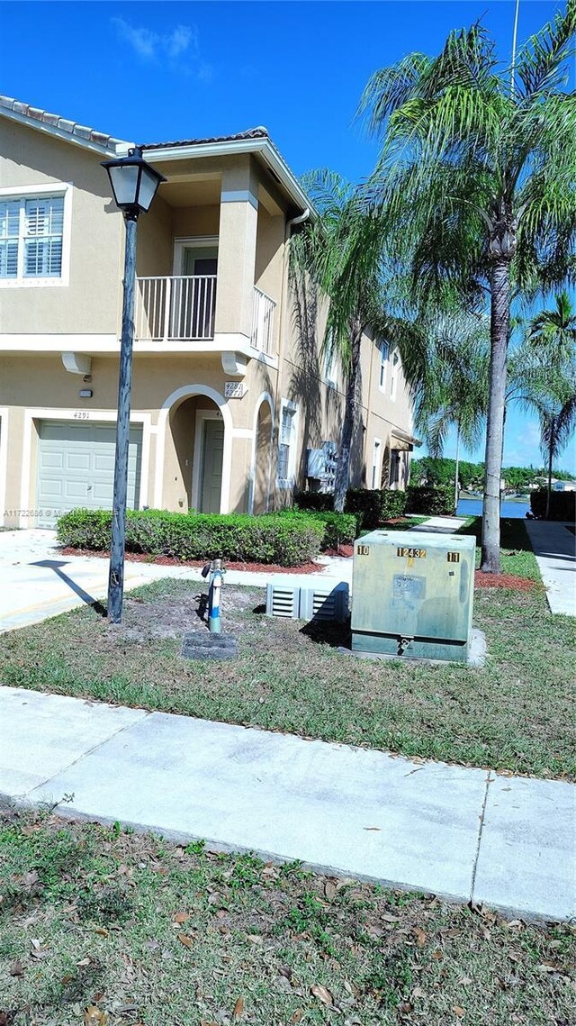 view of front of home featuring a garage and a balcony