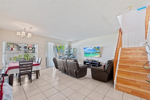 living room featuring an inviting chandelier, light tile patterned flooring, and a textured ceiling