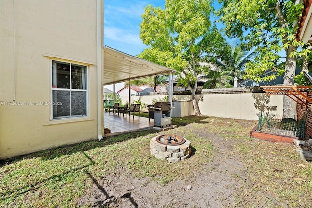 view of yard featuring a fire pit and a patio area