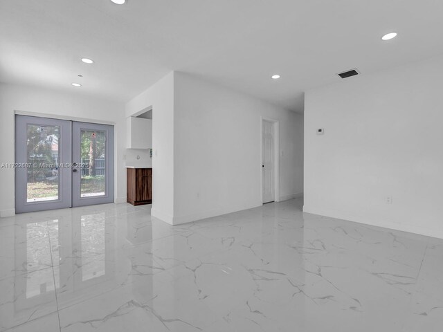 unfurnished room featuring french doors