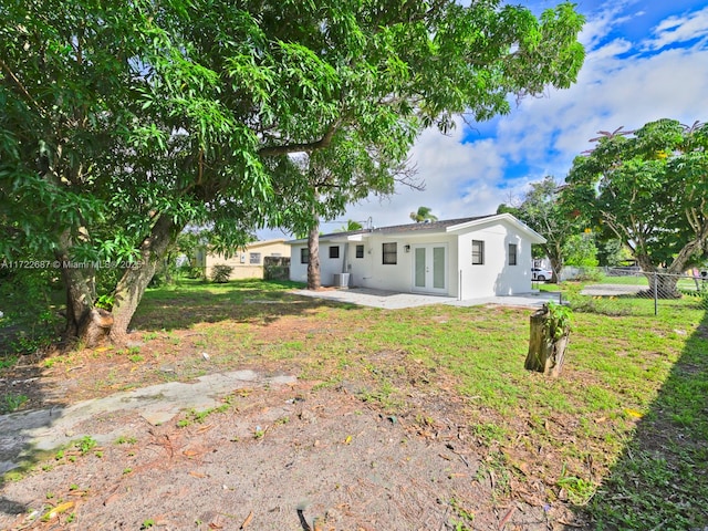 back of property featuring a lawn, a patio area, and french doors