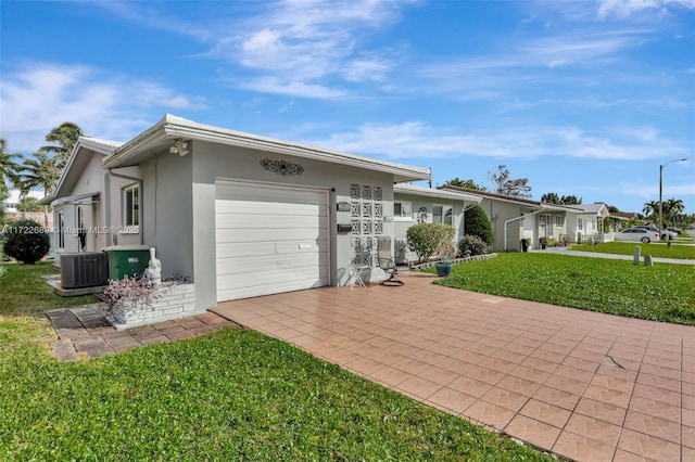 single story home featuring central AC, a front yard, and a garage