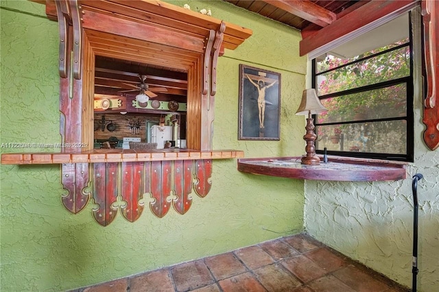 bar featuring ceiling fan, beamed ceiling, and wood ceiling