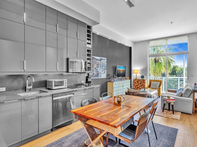 interior space with sink, light hardwood / wood-style floors, and a wall of windows