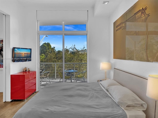 bedroom with wood-type flooring and access to outside