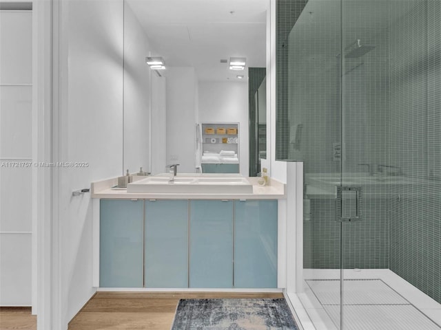 bathroom featuring vanity, hardwood / wood-style floors, and a shower with shower door