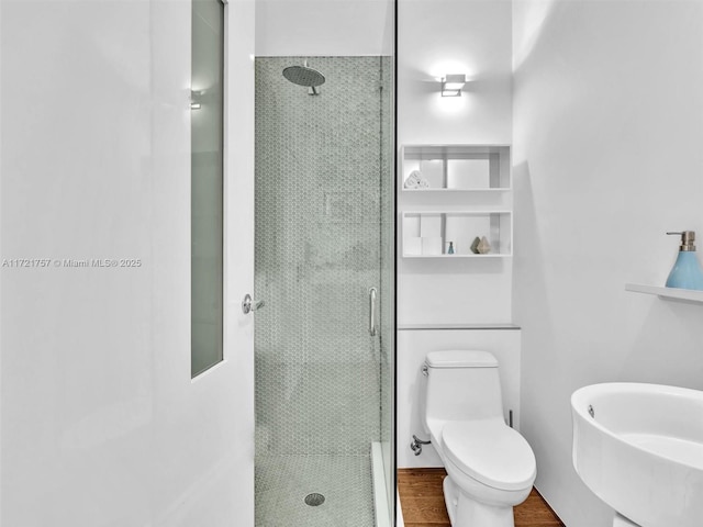 bathroom with sink, wood-type flooring, toilet, and a shower with door