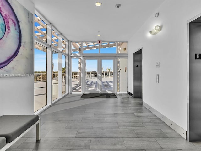 corridor with a wall of windows and elevator