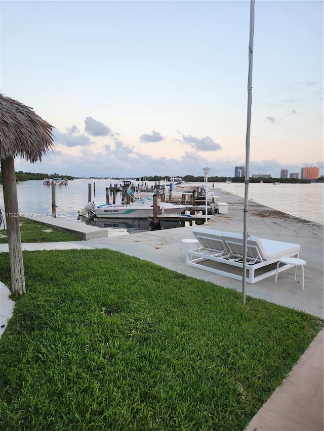 view of dock featuring a lawn and a water view