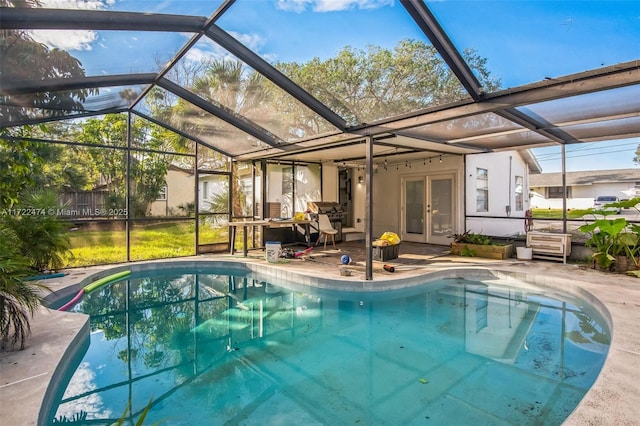 view of swimming pool with glass enclosure, a patio, and french doors