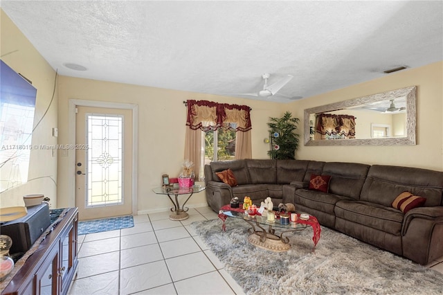 living room with light tile patterned floors, a textured ceiling, and ceiling fan